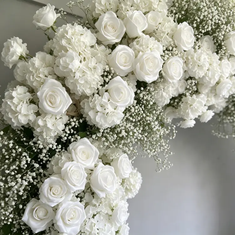 Close-up Detail of Dense White Roses Hydrangeas Baby's Breath and Green Foliage on Artificial Flower Arch