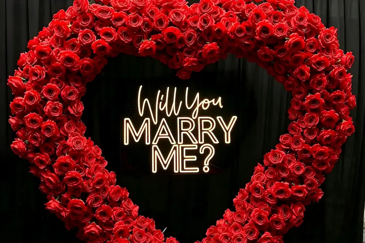 will you marry me sign detail with red heart arch